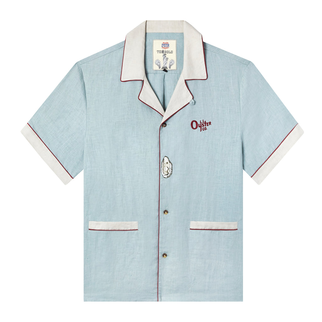 Tombolo x Billion oyster project sky blue linen shirt with Oyster on top of middle button and red embroidered Oyster co. logo on left breast, and white lining