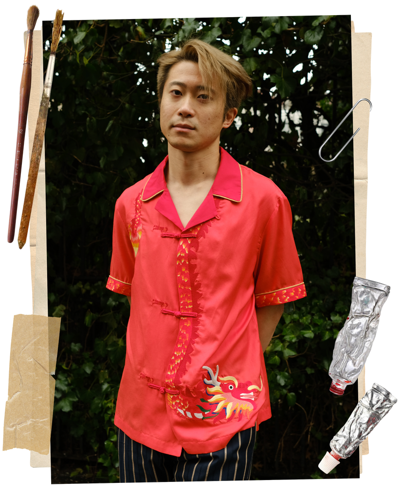 Artist Jiannan Wu wearing a Tombolo x Jiannan Wu red button down shirt with a dragon on it in front of a green background