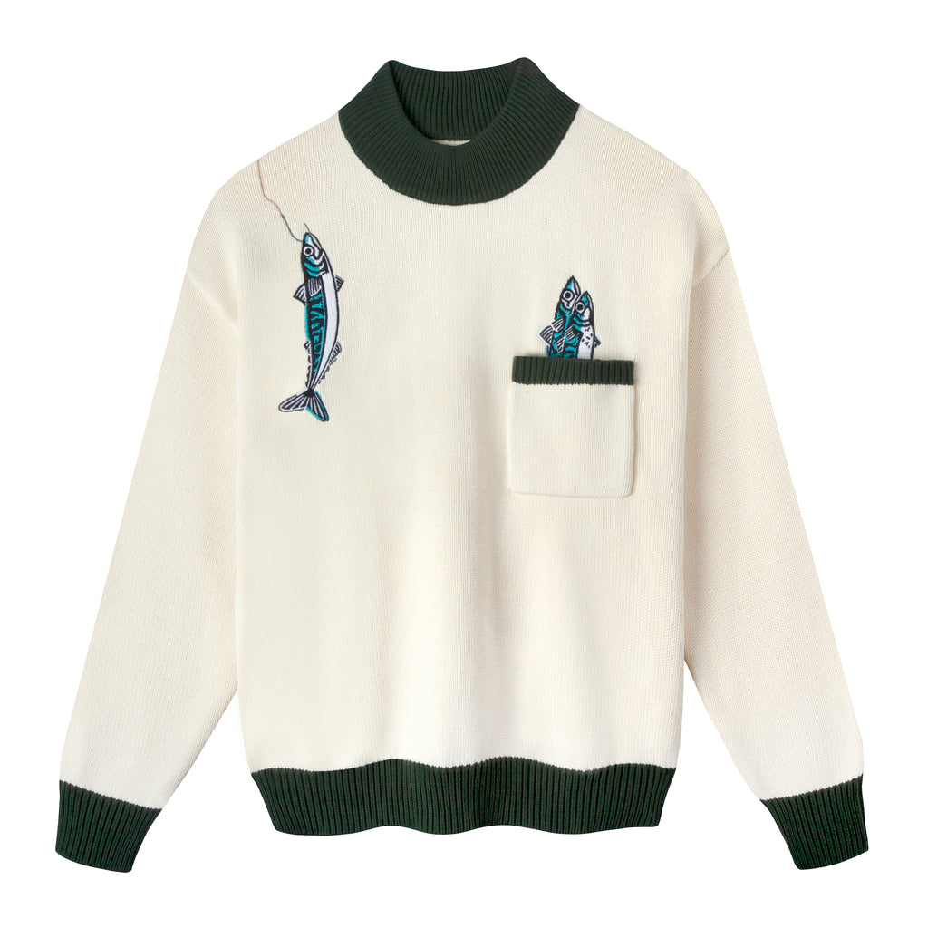 Front view of this drop shoulder, mock neck sweater which is beige with forest green contrasts along the ribbed collar, cuffs, top of pocket, and hem, also features an embroidered over-the-shoulder fish along with two fish peeking out of the front pocket