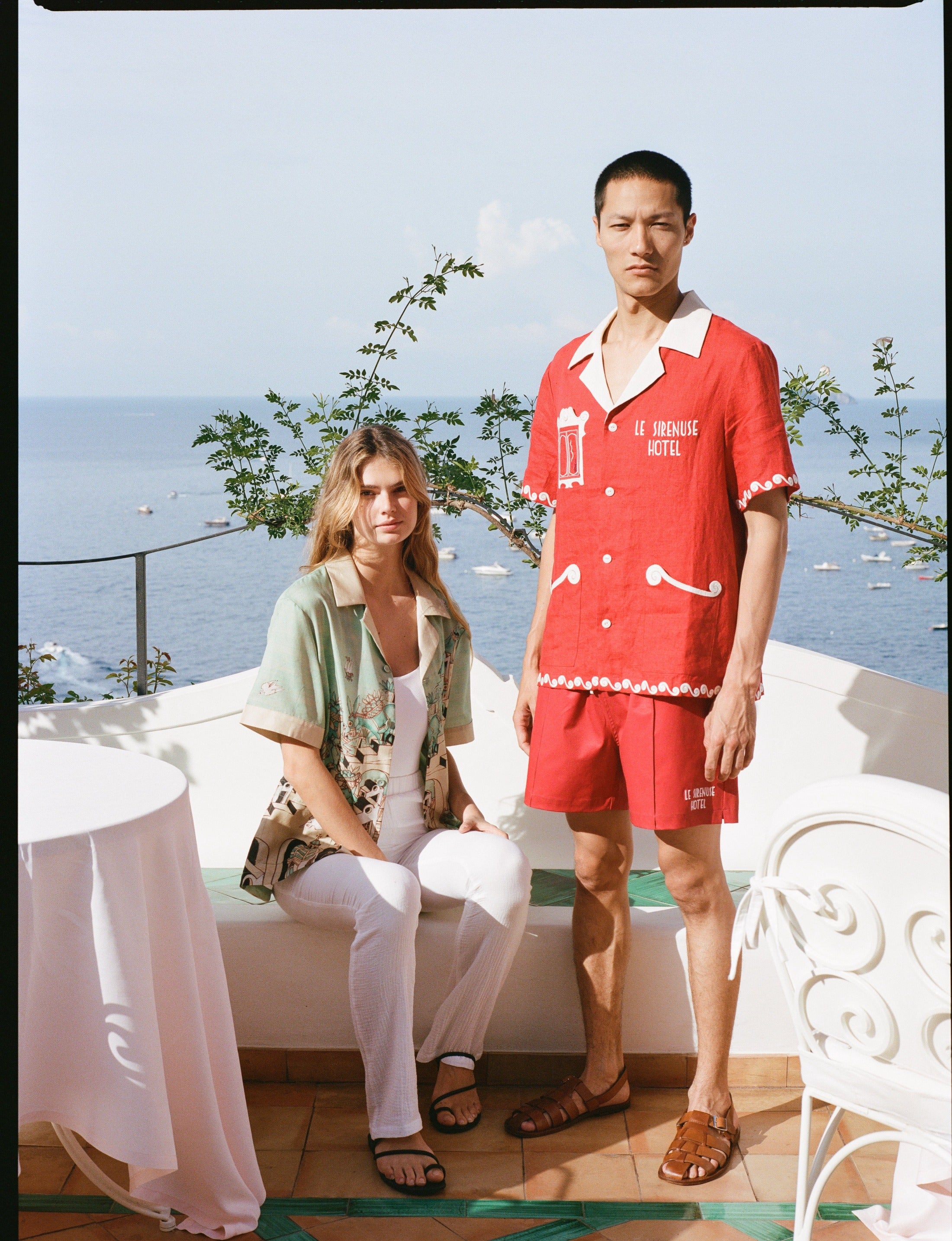 Man and woman in the outdoor dining area of Le Sirenuse wearing the matching finestra set and liguori shirt