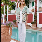 Girl wearing Liguori shirt and white pants standing in front of the pool at the Hotel Le Sirenuse