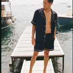 Man standing on dock looking to his right while wearing matching Cabrisa set