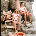 Man and woman sitting on rocks wearing matching Da Adolfo shirts