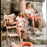 Man and woman sitting on rocks wearing matching Da Adolfo shirts