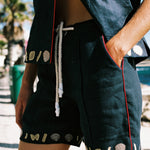 Close up of a female model wearing the crop cut top partially unbuttoned with the matching shorts