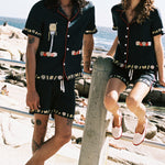 man gazing at camera while woman stares off in the distance both wearing matching linen vongole sets