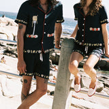 man gazing at camera while woman stares off in the distance both wearing matching linen vongole sets