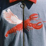 Close up of embroidered lobster with wings on chest