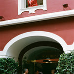 Woman opens window of Le Sirenuse while wearing the finestra shirt