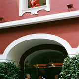 Woman opens window of Le Sirenuse while wearing the finestra shirt
