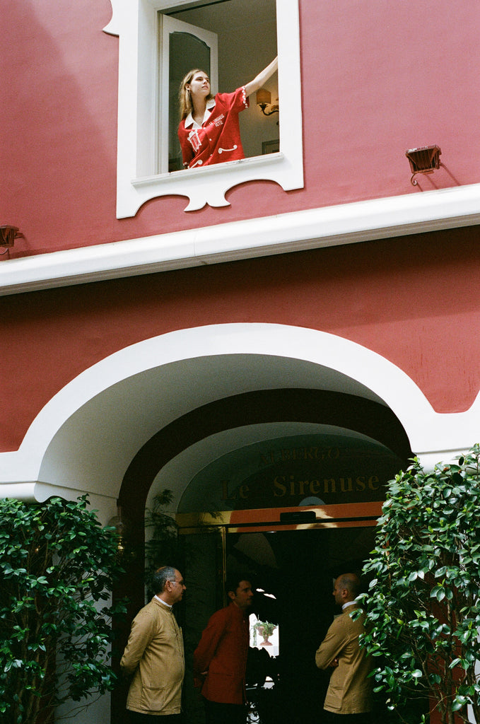 Woman opens window of Le Sirenuse while wearing the finestra shirt