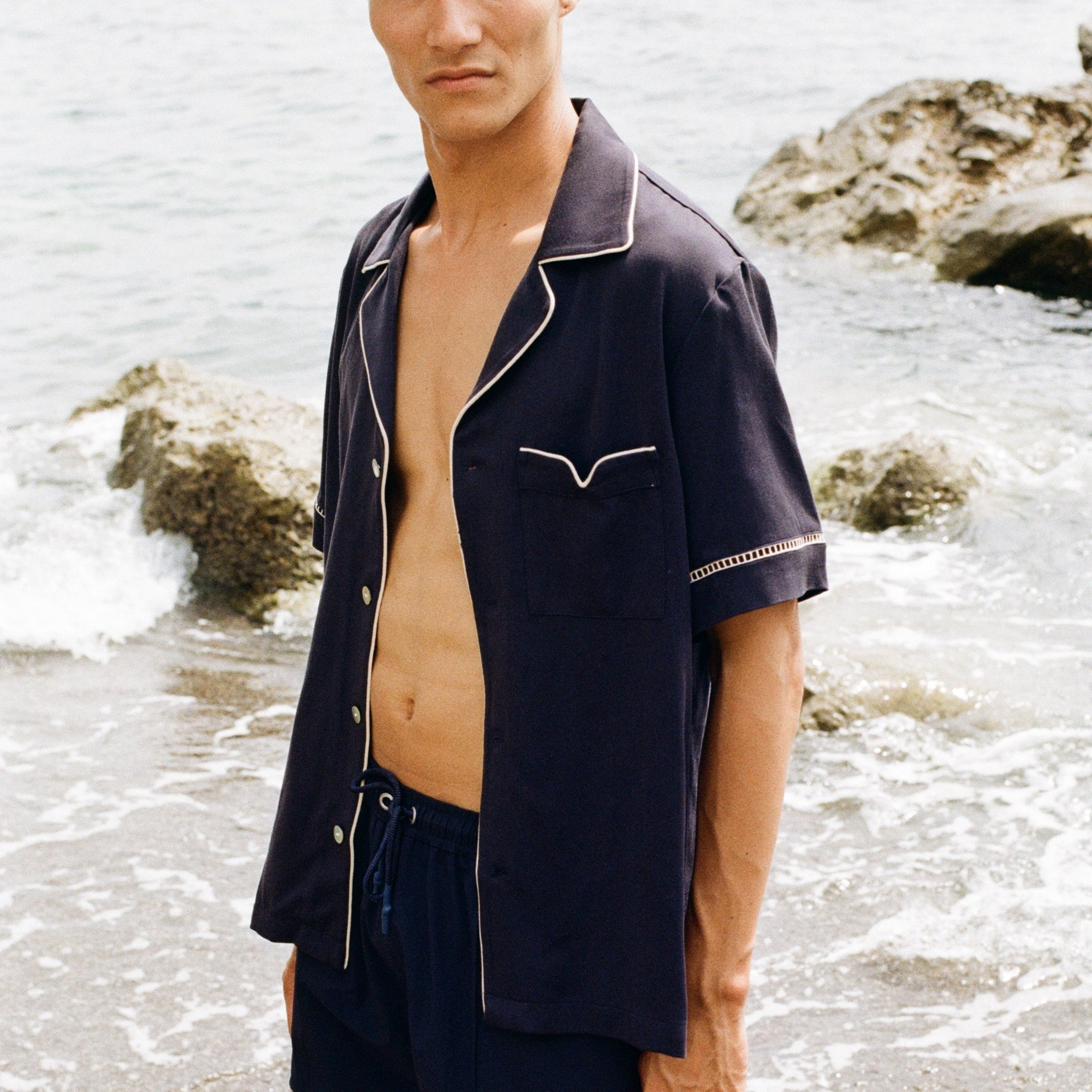 close up of man staring at camera wearing Cabrisa swim trunks with matching open button Cabrisa shirt