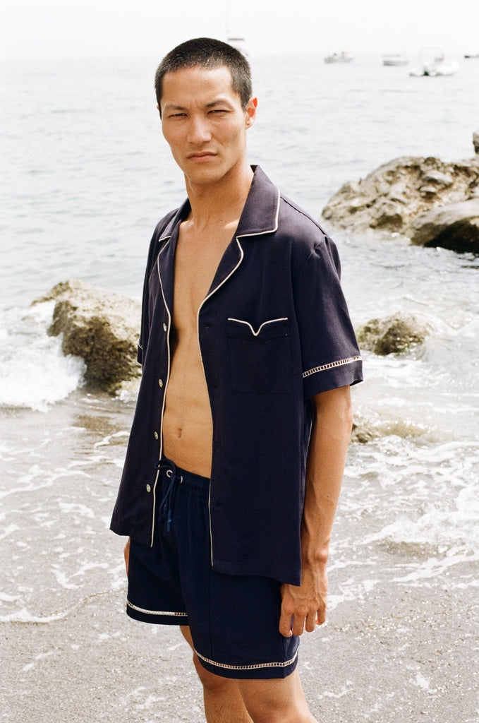 close up of man staring at camera wearing Cabrisa swim trunks with matching open button Cabrisa shirt