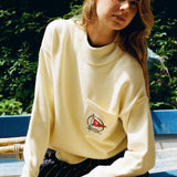 Woman sits on boat leaning forward while looking at camera