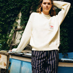 Woman holds hair back while gazing at camera