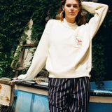 Woman holds hair back while gazing at camera