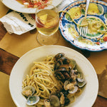 Close up of food from Da Adolfo restaurant, a plate of spaghetti alle vongole and a pomodoro pasta