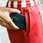 Man puts iphone in hidden zippered pocket of red swim trunks