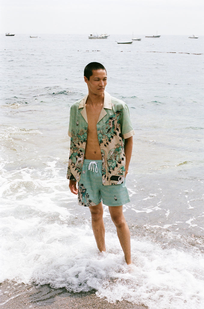 Male model wearing full set with shirt unbuttoned standing in ocean