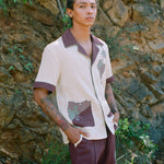 Male model standing against wall with vines wearing full 'Tombarolo' cabana set