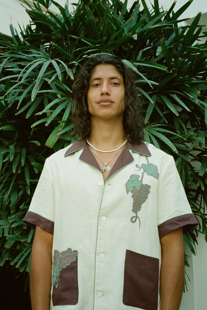 Male model standing in front of palm tree wearing 'Tombarolo' linen cabana shirt