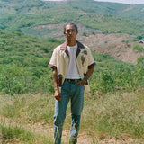 Male model wearing 'Tombarolo' cabana shirt unbuttoned over t-shirt with jeans