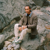 Man sits on rock in quilted jacket