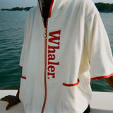 Close-up of woman wearing the white hooded beach towel top with red trim and vertical 'Whaler' text.