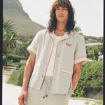 man wearing linen oyster shirt at the beach staring at camera