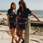 Male and female models on the beach wearing the full matching set with female model gazing at male model