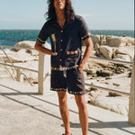 Man staring at camera wearing full matching Navy Tombolo vongole set on a boardwalk