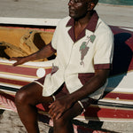 Male model wearing full 'Tombarolo' cabana set sitting on dry-docked boat