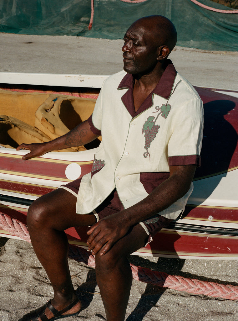 Male model wearing full 'Tombarolo' cabana set sitting on dry-docked boat