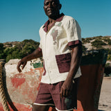 Man in full Tombarolo cabana set leaning against dry docked boat