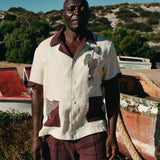 Male model standing among dry-docked boats wearing full 'Tombarolo' cabana set