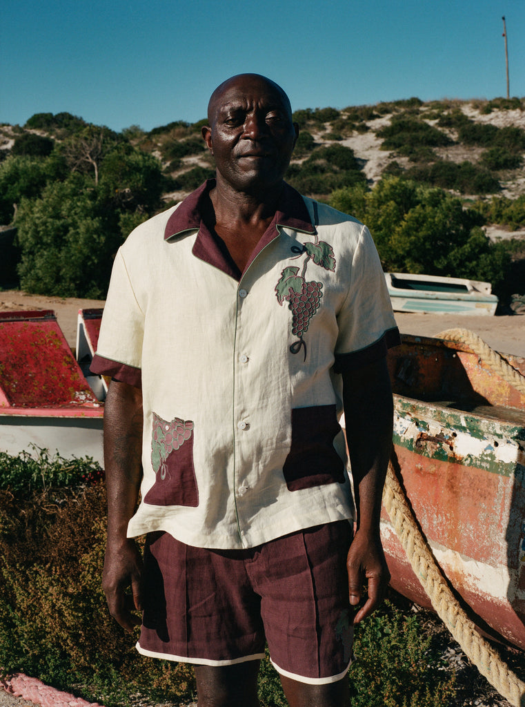 Male model standing among dry-docked boats wearing full 'Tombarolo' cabana set