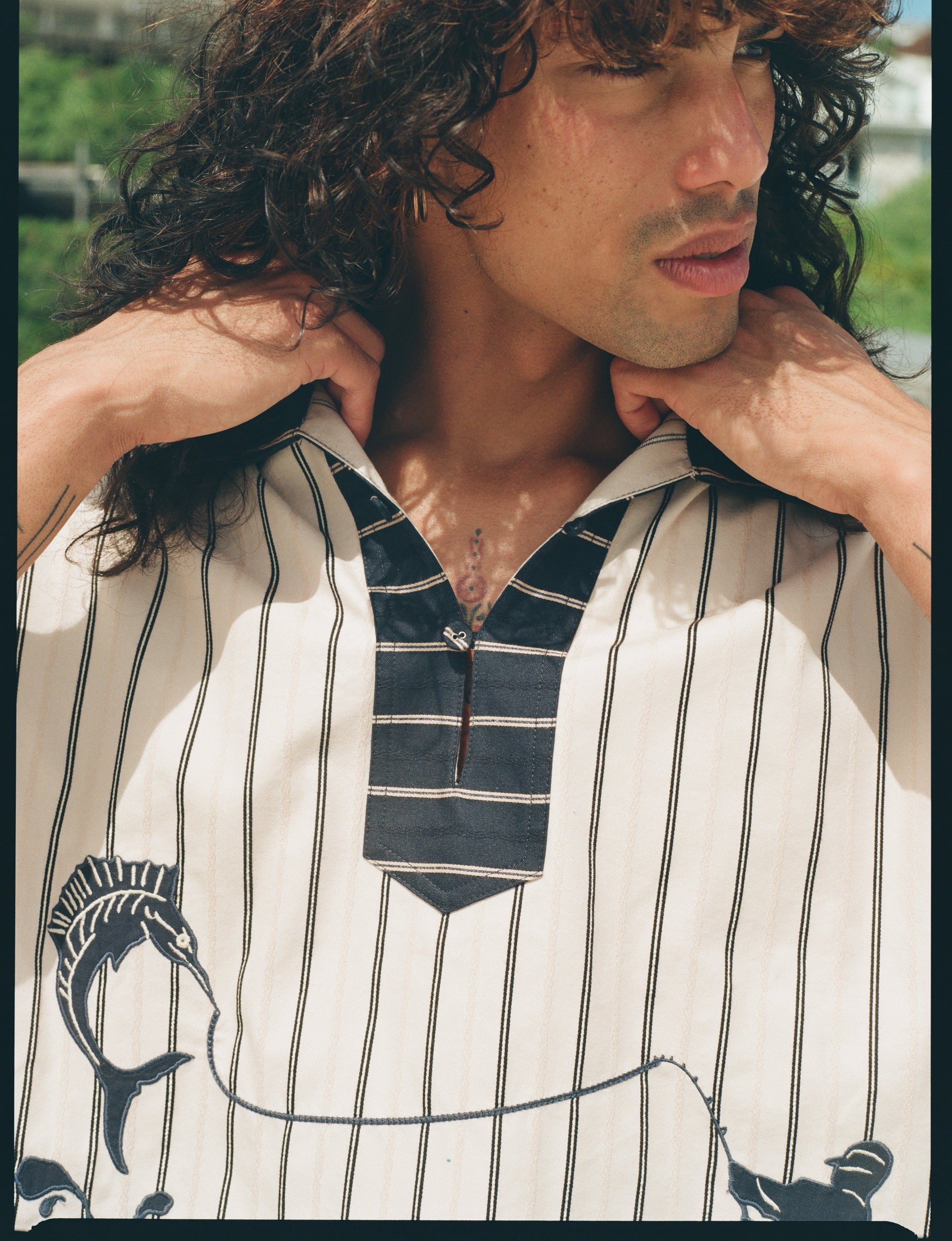 Close up of male model looking to the right, wearing Tombolo striped pop-over shirt