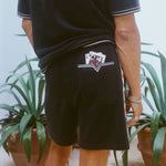 Close-up shot behind a man wearing the 'Vicey Dicey' Shorts, with his hip popped to the right.