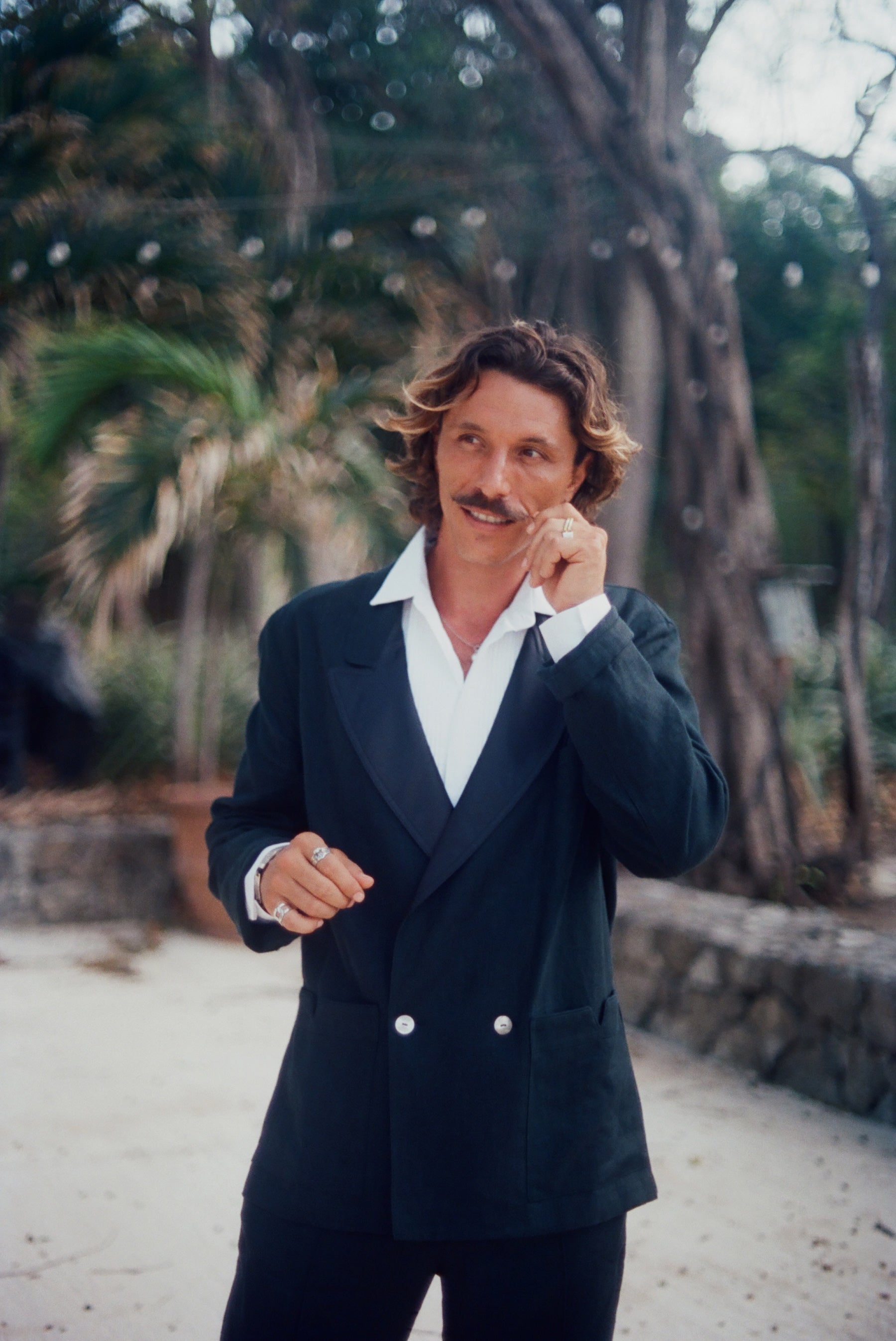 Man wearing the Easy-Going Tuxedo Jacket fully buttoned, and twisting the end of his mustache.