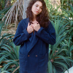 Woman standing outside wearing the Easy Going Navy Linen Shorts and the matching Jacket.