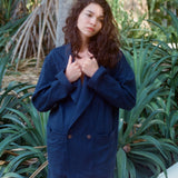 Woman standing outside wearing the Easy Going Navy Linen Shorts and the matching Jacket.