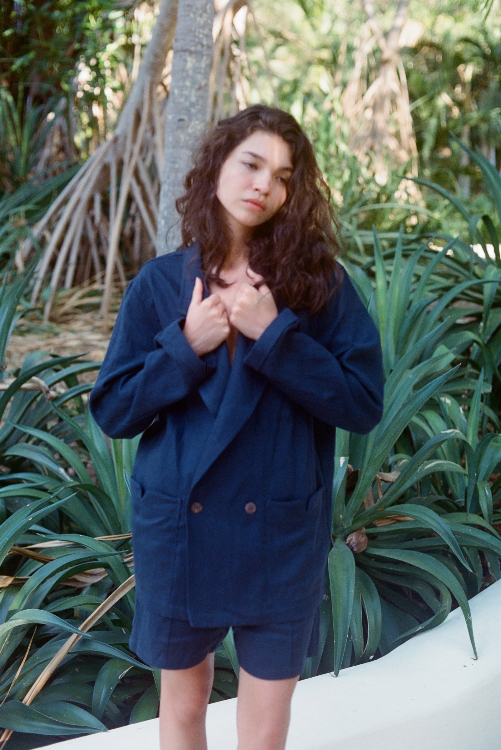 Woman standing outside wearing the Easy Going Navy Linen Shorts and the matching Jacket.