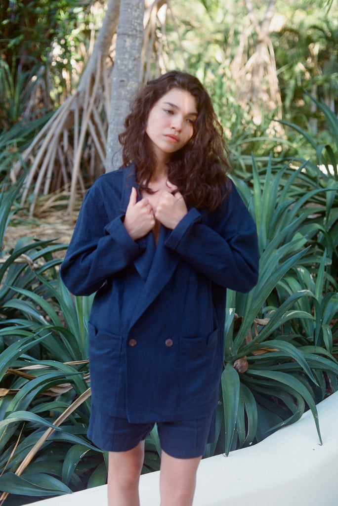 Woman standing outside wearing the Easy Going Navy Linen Shorts and the matching Jacket.