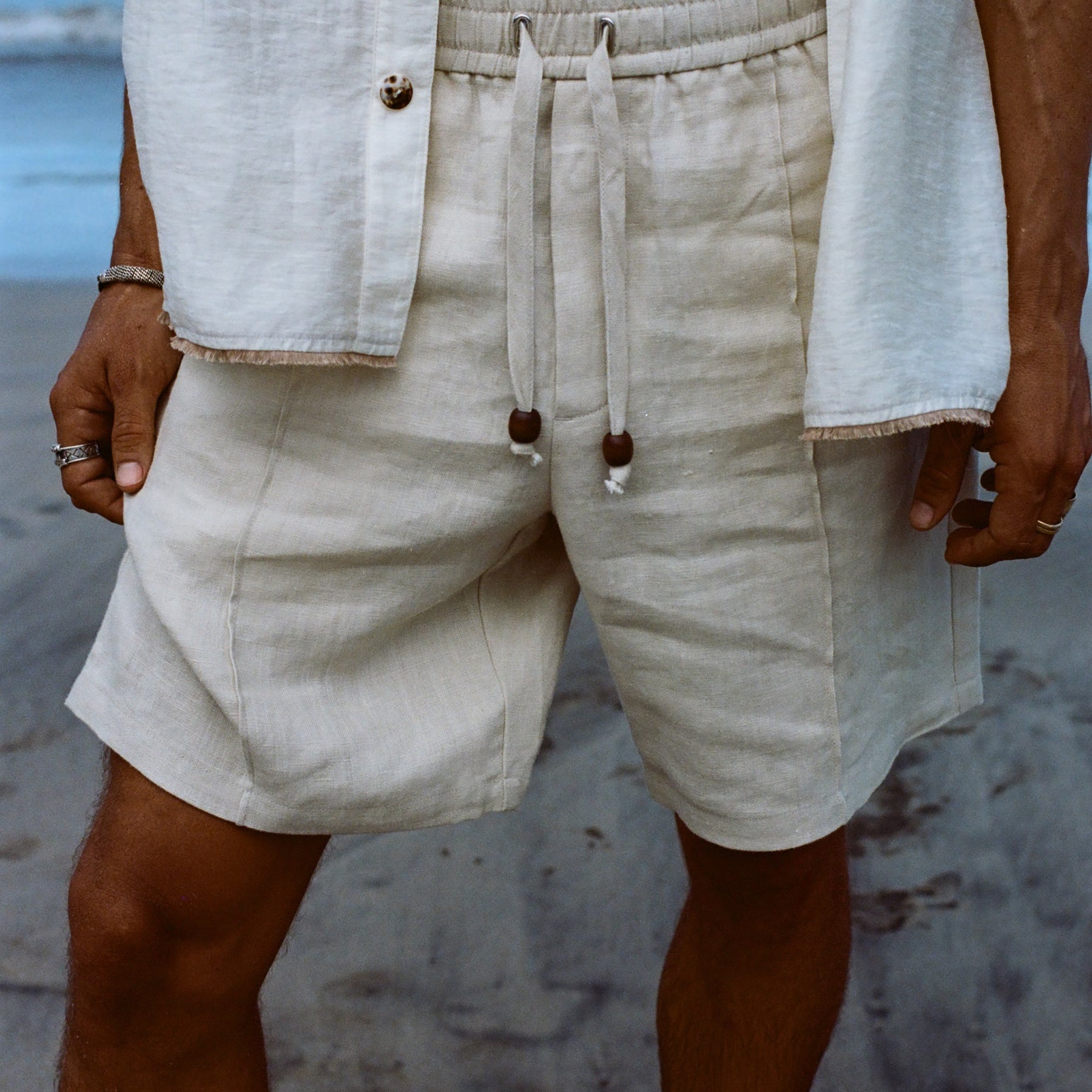 Close-up of man wearing our sand linen Easy Going Shorts with our featherweight Resort Shirt on top. 