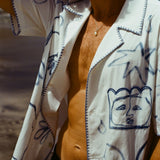 Close up of a man on the beach wearing the Mary Ball Artist Shirt unbuttoned.