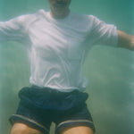 Underwater image of male model wearing our white terry t-shirt with navy swim trunks. 