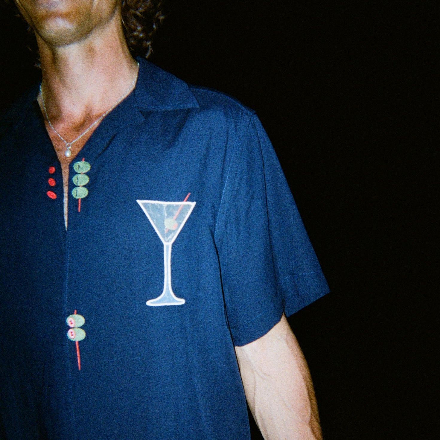 Male model smiling wide wearing the 'Extra Dirty' ~ Relaxed Fit Shirt, featuring a mesh white martini glass over the wearer's left chest. 