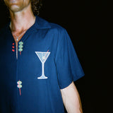 Male model smiling wide wearing the 'Extra Dirty' ~ Relaxed Fit Shirt, featuring a mesh white martini glass over the wearer's left chest. 