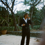 Man wearing the Easy-Going Tuxedo fully buttoned, and twisting the end of his mustache.