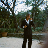 Man wearing the Easy-Going Tuxedo fully buttoned, and twisting the end of his mustache.